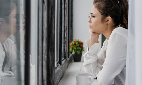 Mulher olhando pela janela curso criança interior ferida
